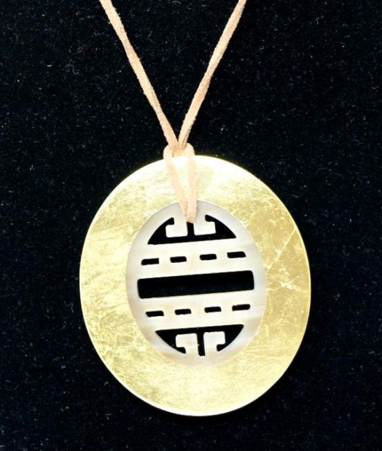 Pendant with gold outer and carved inner close up