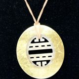 Pendant with gold outer and carved inner close up