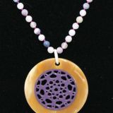 Reversible disc pendant on lilac quartz string, pale horn outer purple inner close up